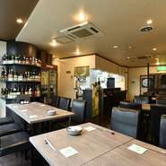 余計な装飾はしない、シンプルですっきりとした心地よい店内。設計と施工は、内装業を営む店主の父と兄が手がけました。酒のボトルをディスプレイできる棚が、ちょっとしたアクセントに。				