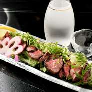 下味を付けた伊賀牛の肉塊の表面を、直火で焼き上げていきます。内側は柔らかく、肉の美味しさがダイレクトに伝わる逸品。特製のタレを付けていただきます。