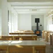 日の光が差し込む窓の外には木々が揺れ、その奥には山と海が広がっています。一歩店内に入れば、暖炉が来る人を温かくもてなします。別荘に来たかのような居心地で、ゆったりと時間が流れ思わず長居してしまいそう。