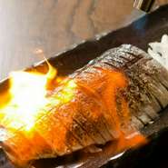 マグロのトロを超える脂がのった〆サバをお客様の目の前でバチバチ炙ります。