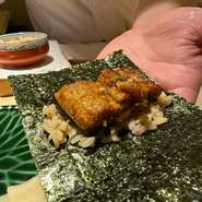 九州 熊本八代より直送される幻の「天然青鰻」。蒲焼にして赤酢のシャリと、香り豊かな有明の最高級海苔で巻いてご提供します。