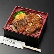 店の味をそのまま自宅で堪能できます。写真は『うなぎ弁当　特松（特上うなぎ7切）』。店内で捌きから焼きまで行った、特製うなぎのかば焼きが7切れ乗ったお弁当です。会合や記念日などにいかが。
