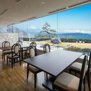 大きな窓から太陽光が降り注ぐ、明るく開放的な店内。どの席からも、ホテルの庭園とその先に広がる駿河湾が眺めながら食事ができる贅沢な空間です。肩肘張らずに過ごせる、カジュアルな雰囲気も魅力。　