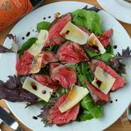 女性におすすめ。さっぱりとした赤身のお肉を、ルーコラとチーズ、バルサミコと共に頂く『牛サガリのロースト　タリアータ』。肉料理でありながら脂っこさはなく、女性でも食べやすい味わいと大好評の逸品です。