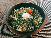 沖縄風炊き込みご飯「じゅーしー」を使ったビビンバ。具は、【からし菜】、【特製キムチ】、【もやしのナムル】、【温泉卵】。熱々鉄板でよく混ぜて召し上がれ。