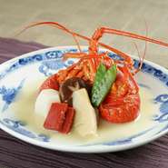 伊勢海老を殻付きのまま煮た、目でも楽しめる豪快な料理です。白味噌で煮た椎茸、筍（夏は冬瓜）を添えて。素材を活かした味付けに、調理人の巧みな技が冴えわたります。