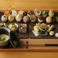 月替わりで手鞠鮨、天ぷら、おばんざい、茶碗蒸し、旬の新鮮な食材を使った季節感溢れる料理です。
メニューの構成上、多種多様な食材を使用しておりますので、アレルギーや苦手食材への個別対応は致しかねます。

