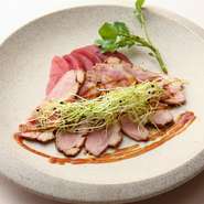 焼き色をつけた良質な鴨肉に、赤ワインと玉ねぎの入った秘伝のソース。赤ワインで煮たリンゴを添えて。