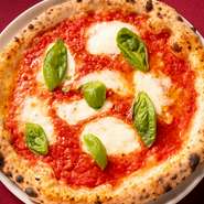トマトソース・モッツアレラチーズ・バジルの定番ピッツァ。シンプルでピッツァそのものの美味しさがよくわかる一品です。生地をつくる粉、トッピングのトマトソース、モッツアレラすべてイタリア産。