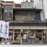 こんぴらさん参道口に店を構える【焼鳥　骨付鳥田中屋】。趣のある町屋にかかったのれんと開放的な店構えに期待が高まります。1人で訪れるゲストも気軽に立ち寄れる町の人気店です。