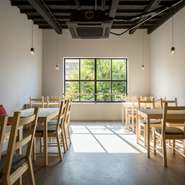 白い壁、白木のテーブルなど、ナチュラルなテイストでまとめられた内装。清潔感があり、大窓から陽光が差し込む明るい店内は誰にとっても気持ちいいスペース。