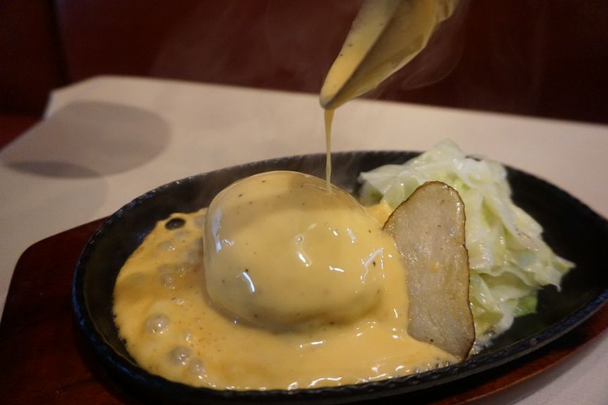 目の前で特製チーズソースをかけて仕上げる『チーズハンバーグ』