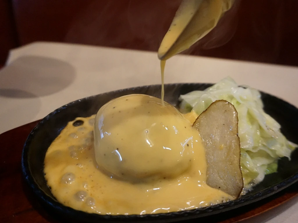 目の前で特製チーズソースをかけて仕上げる『チーズハンバーグ』