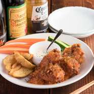 味付けした手羽元を揚げ、オリジナルの辛味ソースで絡めました。野菜スティックやフライドポテトを一緒に盛り付けた、パーティーにおすすめの一品。お友達とシェアして楽しんでください。 