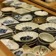 カウンターに並ぶ豆皿や酒器などの器もゲストの目を楽しませます。その中心となるのは福岡県筑紫野市や佐賀県唐津市などで活動する作家の作品。食材同様に、窯元まで訪れ、つくり手との関係性を築きあげます。