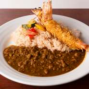 鳥の挽肉が素材感満点な『キーマカレー』。カレーのご飯の色は玉ねぎの皮を煮出した水で炊いたもの。小エビを衣にした小麦粉不使用の大海老フライなど、トッピングもいろいろ楽しめます。