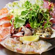 ＜カルパッチョ・マリネ・フリット・スモークetc＞たっぷり盛り付けられたカルパッチョ。“イタリアン魚酒場”の名のとおり、当日競りで買い付けした新鮮な魚介類の豊かな味わいを堪能できる一皿です。