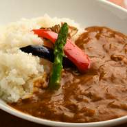 季節野菜の素揚げを乗せたヘルシーなカレー。ルーは、ビーフカレー、ポークカレー、チキンカレーの3種類あり、日によって種類が異なります。誰もが気軽に食べられるように、万人受けする辛さ。※数量限定です。