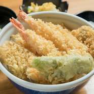 大きな海老が2本、魚、鶏肉、オオタニワタリを含んだ野菜と具だくさんの『天丼』。魚はクチナジなど近海で獲れた新鮮な島魚を使っています。かすかにほろ苦いオオタニワタリの天ぷらは後引く美味しさです。