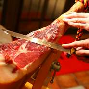 複数の生ハムを食べ比べて選んだ、骨付きの「ハモン・セラーノ」は、スペインの生ハムアワードで金賞を受賞した逸品です。脂と赤身の旨みが際立つ切りたては、さらに上質な味わいです。