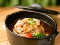 ハンバーグの概念が変わるおいしさ。200gものボリューミーなタネを焼いてから煮込むので、柔らかさとジューシーな旨さが絶品。ソースはデミグラスやトマトソースなど日替わり。上にはとろ～りおいしいチーズが。
