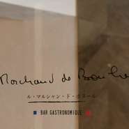 【ル・マルシャン・ド・ボヌール】は仏語で「幸せを運ぶ商人」の意味。森シェフが師と仰ぐスターシェフ、ミシェル・ブラス氏から貰ったメッセージにある言葉で、その直筆を店のロゴに。