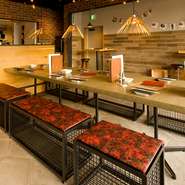 焼肉で元気を付けたくなったら帰って来てワイワイしたくなるような「家の中庭」がお店のインテリアのコンセプトです。みんなが集まるテーブルを温かく照らすのに選んだ照明はゴールドのトングなんですよ。