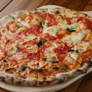 石窯による500度の高温で一気に焼き上げたピザは、手づくりの生地がふんわりモチモチ。粉は本場こだわりのルスティカを使用しています。ピザはオリジナルの『どんちゃかピザ』など全部で10種類あります。