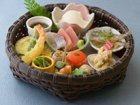 お造り、揚物、煮物など少しずつをかごに盛り付けたミニ会席。