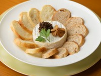 焼いたカマンベールチーズをパンにつけて食べる一番人気のメニュー。カマンベールチーズは鉄板で焼くと外側は硬いまま、中がチーズフォンデュのようにトロトロに。レーズンとニンニクチップ付き。