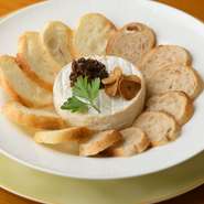 焼いたカマンベールチーズをパンにつけて食べる一番人気のメニュー。カマンベールチーズは鉄板で焼くと外側は硬いまま、中がチーズフォンデュのようにトロトロに。レーズンとニンニクチップ付き。