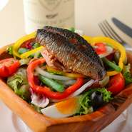 塩漬けした真イワシをオイルでマリネにし、カリッとフライパンで焼き上げサラダの上に。ボリュームたっぷりの季節の有機野菜などと共に味わう人気メニュー。