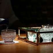 マホガニー素材の一枚板で作られたカウンターや落ち着いた色合いで纏められた店内はゆったりと落ち着ける空間。また繊細な輝きを放つ江戸切子の酒器など、空間はもちろん、調度品にも店主のこだわりがうかがえます。