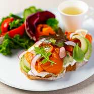 スモークサーモンとクリーミーなアボカドをベースに、フレッシュなディルや季節の野菜をトッピング。ジューシーなワカモレソースを合わせ、絶妙なバランスで風味が広がります。サラダとスープをセットでご提供。