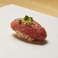 普通、ネギトロは軍艦巻きで供されますが、【つむぎ】ではパフォーマンスを重視。目の前で大きな包丁を使いネギトロをつくり、軍艦巻きではなく、握りで提供されます。米は時期によって鮨に合うものを厳選。