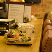 9席のカウンターはそれぞれにコンロが用意されているので、浜焼きや自慢の焼酎を楽しめます。賑やかで明るい店の雰囲気なので、一人での来店でも楽しく過ごせます。月～木曜は定食もあり、食事どころとしても人気。