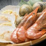 東京湾のシロハマグリ（ホンビノス）、噴火湾のホタテ、上質な赤エビといった極上の海産物を、テーブルのコンロで香ばしく焼き上げます。テーブル備え付けの醤油を垂らすなど、お好みの味付けで。写真は2人前。