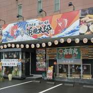 大漁旗を思わせる豪快な看板が目印。ちょうちんも灯り、明るく活気満点の店がイメージできます。