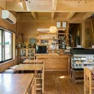 オーナー夫妻の手づくり家具が並ぶ、木目調の温かみがある内観。店内では、コーヒーを飲みながら本を読んだり、食事が終わった後におしゃべりを楽しんだり、ゆったりとした時間が流れています。