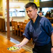 「来店してくれたお客様を料理や接客でおもてなしし、お腹も心も満たして満足して帰ってもらう事を心掛けている」というオーナーの金城氏。県産食材をふんだんに取り入れた沖縄料理でもてなしてくれます。