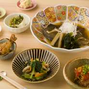 毎日つくられる日替わりの煮魚に小鉢が五～六皿付いた、いろいろな料理を少しずつ楽しめるお得なおつまみセットです。季節や仕入れ状況で料理内容が変わるので、いつ訪れても食べ飽きません。