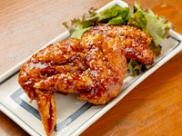 表面はカリッと、中はジューシー。甘辛いタレはお酒にもご飯にもよく合う『やみつき手羽先（二本）』