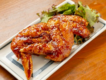 表面はカリッと、中はジューシー。甘辛いタレはお酒にもご飯にもよく合う『やみつき手羽先（二本）』