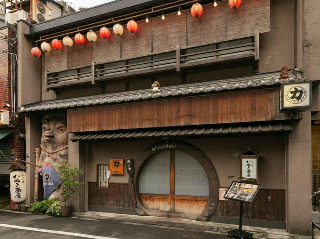 大きなたぬきの置き物が鎮座する店舗入り口