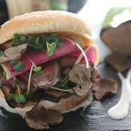 バンズからはみ出すほどに盛られたローストビーフにトリュフを散りばめて