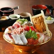 黄金の器に盛り付けられた、鮑に箱雲丹に旬のネタ。どんぶりひとつで今味わうべき海の幸を網羅。贅沢を体現するメニューです。