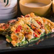 外はパリッと、中はしっとり焼き上げた『アサリとイカのネギのチヂミ』。自家製のつけだれを付けて食せばネギの香りとイカやアサリの海鮮独特の旨味が口いっぱいに広がります。相性が良いマッコリとともに楽しんで。