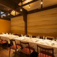 美しい風合いの土壁は、レストランの母体【金沢ワイナリー】の葡萄畑が広がる河北潟・穴水・珠洲の3種の土を用い、石川のテロワールを表現したもの。金沢の作家集団secca製の皿など、空間＆器の趣向も格別。