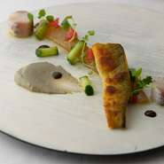 夏の皿の例。鮎の多彩な魅力を伝える為、香ばしく焼き上げた身、丸く成形してしっとりと仕上げた優しい食感の一片、内臓の旨みがつまる鮎のリエットを一皿に。加賀の太きゅうりと半乾燥スイカで、季節の香りをプラス