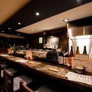 10席あるカウンター席は、なんとも心地よい空間。1人でスポーツ観戦をしながらもよし、流れる音楽を聴きながら、会話を楽しむもよし。思い思いの時間を過ごせるのが『力士飯　嵯峨泉』の魅力です。